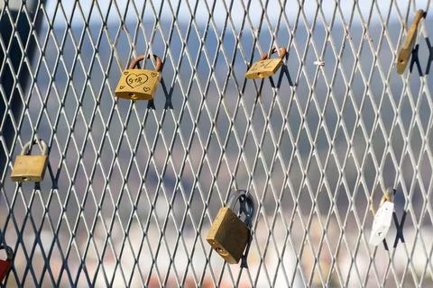 View of many old rusty padlocks on the iron fence of the bridge Stock Photos