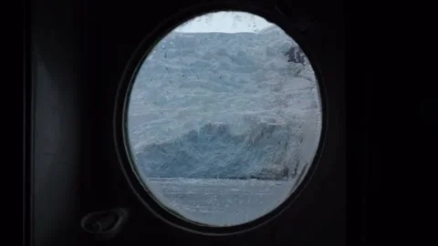 View of a Massive Blue Glacier Through a Ship Cabin Porthole in Antarctica Stock-Footage 339651515