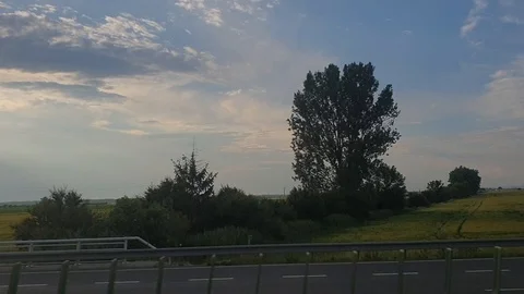 The view of meadows, clouds and roads through the bus window while driving Stock Footage 111420985