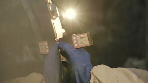 View of measuring a thickness of primer on a car surface using a thickness gauge Vidéo 86829033