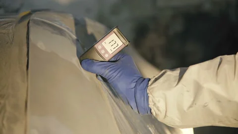 View of measuring a thickness of primer on a car surface using a thickness gauge Vidéo 86870012