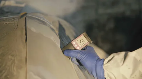 View of measuring a thickness of primer on a car surface using a thickness gauge Stock Footage 86870057