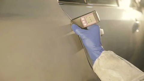 View of measuring a thickness of primer on a car surface using a thickness gauge Video stock 86870594