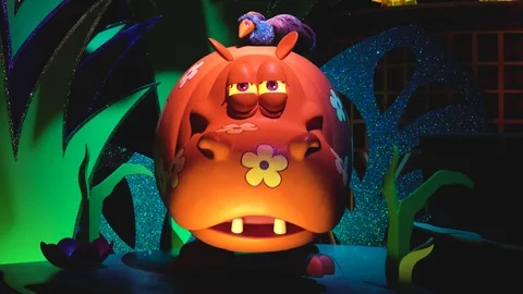 View of a mechanical attraction with a funny orange hippo dancing and Stock Footage 116370515