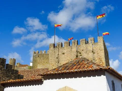View of the medieval walls, tower, flags, and  historic house Stock Photos