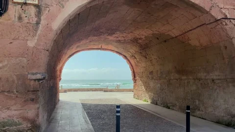 View of the Mediterranean Sea framed through a historic stone arch in Altafulla, Stock Footage 331672194