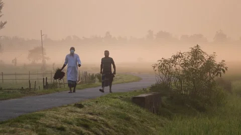 View of men walking on a misty rural road in Bogura, Bangladesh. Stock-Footage 335589514