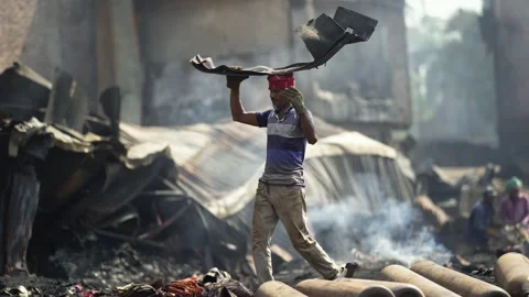 View of men working amidst smoke and debris in Dhaka, Bangladesh. Stock Footage 335600304