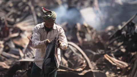 View of men working in a scrapyard with metal debris, Bangladesh. Stockbeeldmateriaal 335600283