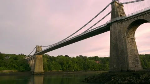 View of Menai Suspension Bridge underneath during sunset hour in the summer Stock Footage 162499515