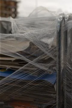 View of metal frame supporting stacked cardboard with plastic wrap Stock Photos