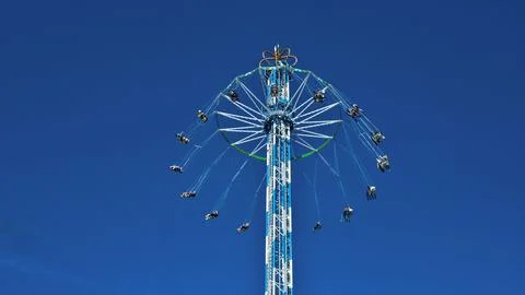 View of the metal structure of a carousel and other mechanical rides in an .. Stock Photos