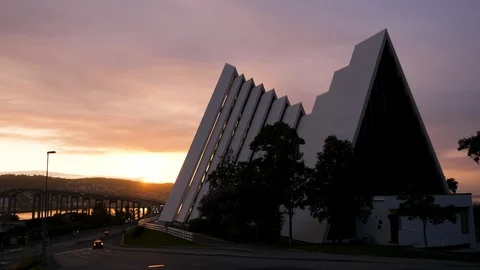 View of midnight sun with Arctic Cathedral and car traffic on Tromso city bridge 動画素材 113735186
