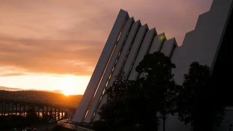 View of midnight sun with Arctic Cathedral and car traffic on Tromso city bridge 動画素材 113737640