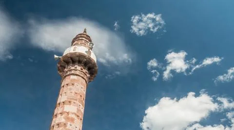 View of minaret of a mosque with moving clouds. Stock Photos