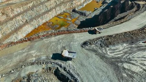View of mining trucks transporting minerals to the leaching pads Stock Photos