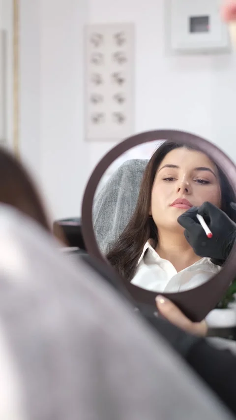 View in the mirror microblading, lip tattoo, permanent makeup. Vertical video Stock Footage 250439914