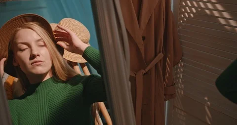 View on the mirror in which pretty blonde smiled woman fashion blogger trying on Stock Footage 122516421