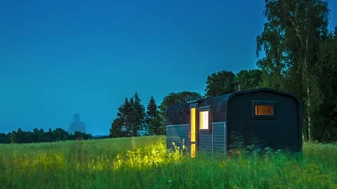 View of a modern dark-colored tiny house in a meadow, LATVIA. Video stock 340639024