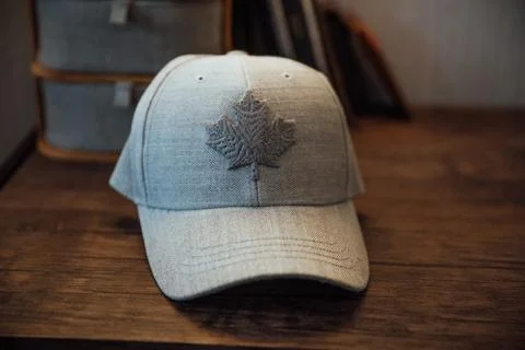 A view of a modern gray baseball cap with the design of a maple leaf on it on Stock Photos