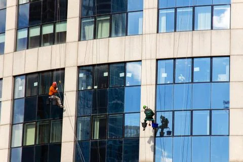 View on modern skyscrape, workers on the ropes cleaning windows Stock Photos