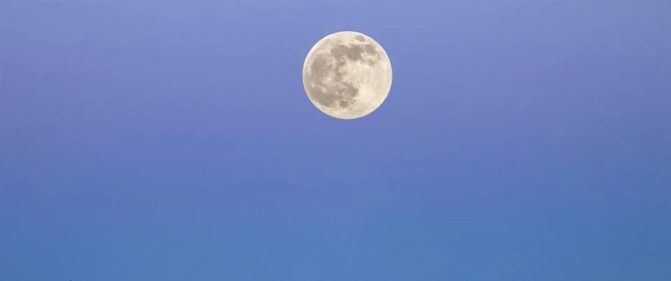 View of the moon emerging in the sky. Stock Photos
