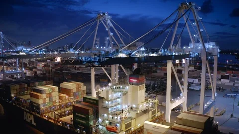 View of the moored container ship unloaded by two port cranes at night in Port Video stock 120313449