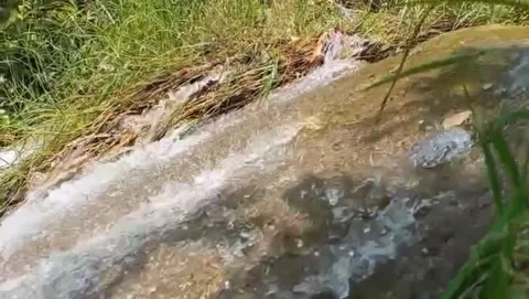 A view of mossy rocks with a fast flowing river. Video stock 332158624