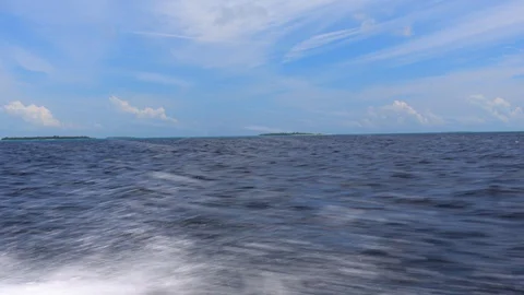 View from a motor boat fast moving across the sea past the islands. Maldives. 4K Stock Footage 128393463