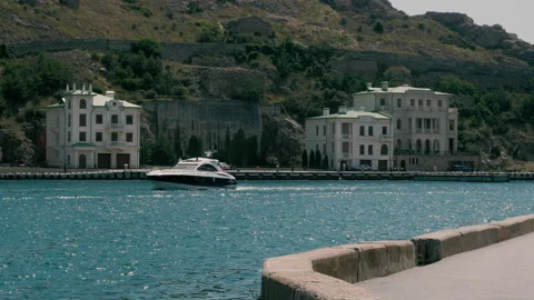 View of motor boat moving alongside waterfront in Balaklava Bay, Crimea Video stock 160109737