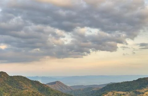View of mountain and forest with cloudy sunset sky Stock Photos