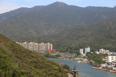 A view of the mountain and river from one side, with buildings on both sides Stock Photos