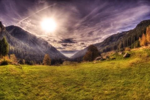 View from a mountain in austria with dramatic sky and sun Stock Photos