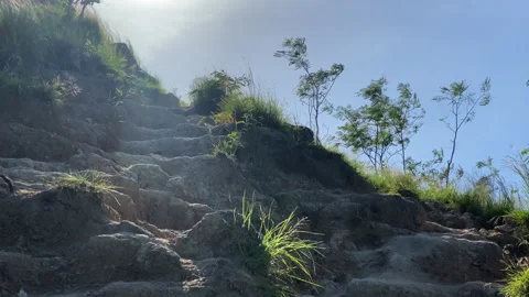 A view of a mountain cliff hill with clear sky and grass Stock Footage 276180414