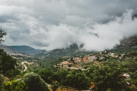 View on mountain with low hanging clouds and green trees. South Crete neat Foto stock