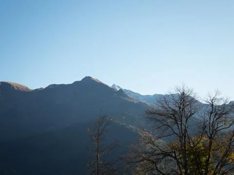 View of the mountain peaks in the backlight against the blue sky Fotos Stock