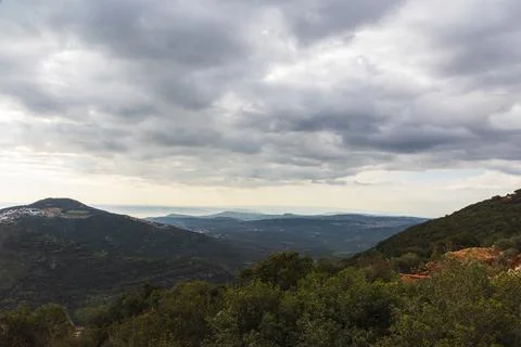 A view of a mountain range and a green valley in the morning at sunrise, against Stock Photos
