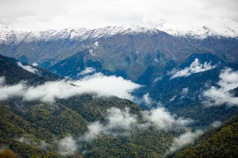 A view of a mountain range with clouds coming out of the valley Stock Photos