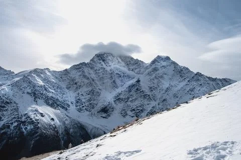 View of the mountain range, steep slopes and snow-capped rocky peaks. Stock Photos