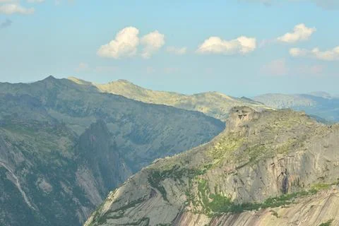 A view of a mountain range with tall, jagged cliffs and sheer slopes under .. Stock Photos