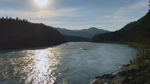A view on a mountain river, a forest and mountains in the sunset Stock Footage 92670851