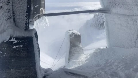 View from mountain shelter above clouds icy wind blowing snow Stock Footage 345800695