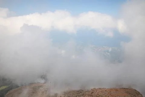 View from the mountain to the sky, through the huge clouds you can see the ci Stock Photos
