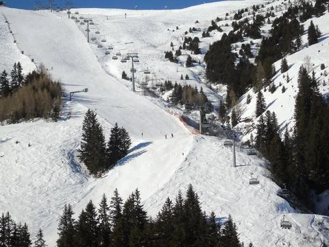 View of the mountain slope on which the ski slope and the ski lift Stock Photos
