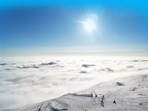 View from mountain summit of snow covered plateau in clouds Stock Photos