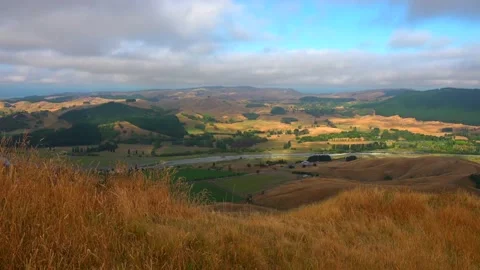 View from the mountain Te Mata Peak to clouds, river and hills with yellow grass Stock Footage 131774826