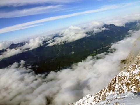 View from the mountain to the valley and the clouds above it Stock Photos