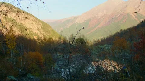 View of mountain valley covered with sunshine at background and with shadow at Stock Footage 145745652