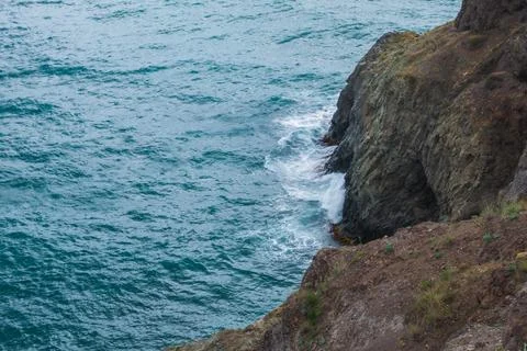 View from the mountain to the waves of the sea. Stock Photos