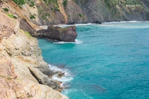 View from the mountain to the waves of the sea. Stock Photos